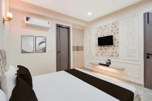 a bedroom with a bed and a tv on a wall at Townhouse DSIDC Bawana Formerly Kanhaiya Residency in Bawāna