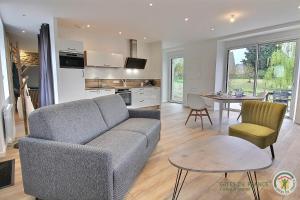 ein Wohnzimmer mit Sofa und Tisch in der Unterkunft La parenthese in Beaussais sur Mer