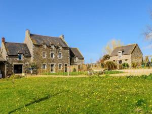 ein altes Steinhaus mit einem grünen Hof in der Unterkunft La parenthese in Beaussais sur Mer