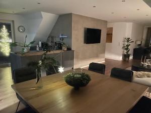 a living room with a wooden table and a living room with a christmas tree at Ferienwohnung Lang in Nümbrecht