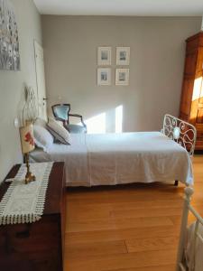 a bedroom with a white bed and a wooden floor at Ciliano 16 in Montepulciano