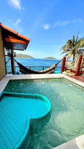 a swimming pool with a view of the ocean at Pousada Vista Grega in Arraial do Cabo