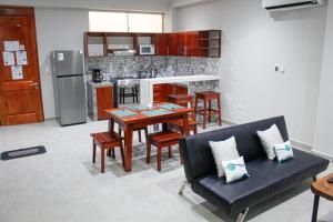 a kitchen with a table and a couch in a room at Bellazio Aparthotel in Iquitos