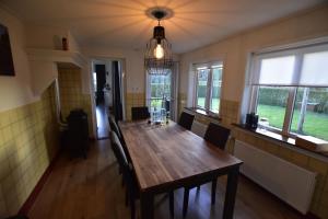 ein Esszimmer mit einem Holztisch und Stühlen in der Unterkunft The Holidayhouse in Loon op Zand
