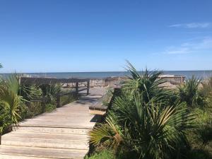 a wooden pathway leading to a beach with the ocean at Honu Kai in Jekyll Island