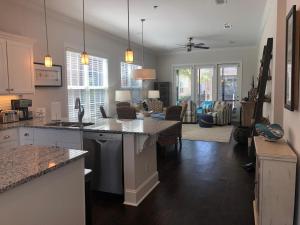 a kitchen with a counter top and a living room at Honu Kai in Jekyll Island