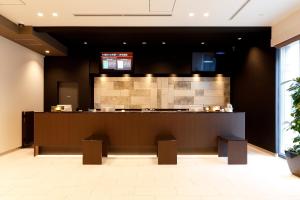 a lobby with a counter and a bar with benches at Dormy Inn Nagano in Nagano