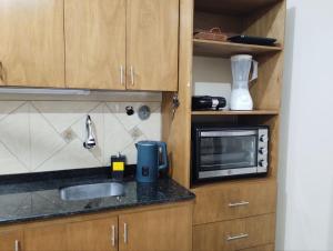 una cocina con fregadero y microondas en Prisma21, en Luque 9 fotos más