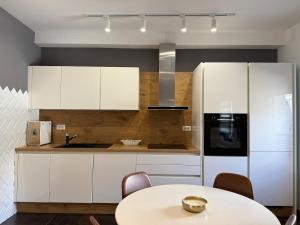 Una cocina con una mesa y un refrigerador blanco. en Linea Apartment, en Belgrado