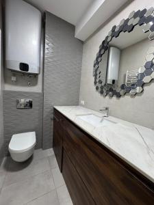 Un baño con inodoro, lavabo y espejo. en Linea Apartment, en Belgrado