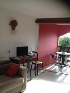 una sala de estar con un sofá, una mesa y sillas en Studio Papaye - confort et calme près des plages, en Sainte-Anne 7 fotos más