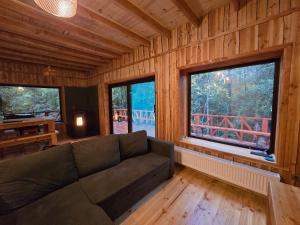 un salon avec un canapé et une grande fenêtre dans l'établissement Casa Mágica en Bosque Huilo Huilo, à Neltume 18 autres photos