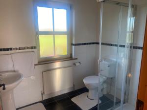 a bathroom with a toilet and a sink and a window at scenic estuary way home in Labasheeda +9 photos