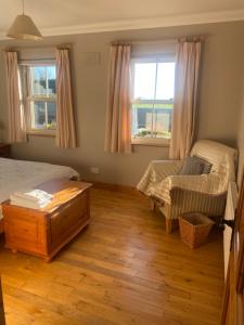 a bedroom with a bed and a bench and two windows at scenic estuary way home in Labasheeda