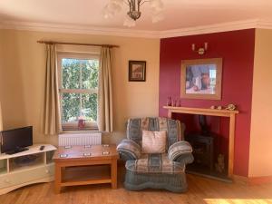 a living room with a chair and a television at scenic estuary way home in Labasheeda