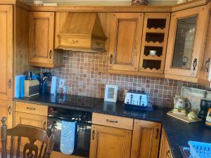 a kitchen with wooden cabinets and a black counter top at scenic estuary way home in Labasheeda