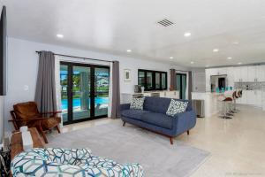 Una sala de estar con un sofá azul y una cocina. en Hidden Gem-Walking Distance to Downtown Cape Coral, en Cabo Coral