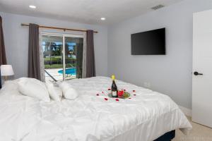 Una cama blanca con una botella de vino y flores encima. en Hidden Gem-Walking Distance to Downtown Cape Coral, en Cabo Coral 20 fotos más
