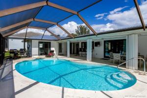 una piscina en un patio con techo en Hidden Gem-Walking Distance to Downtown Cape Coral, en Cabo Coral