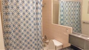 a bathroom with a shower curtain and a toilet at Ariel West Duplex in Jekyll Island +12 photos