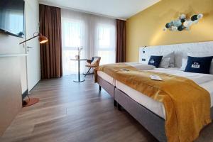 a hotel room with a large bed and a table at Holiday Inn - the niu, Kettle Stuttgart Vaihingen by IHG in Stuttgart +66 photos