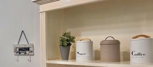 a shelf with three coffee cups and a plant at Nazaré Stay Home - Alecrim T2 in Nazaré