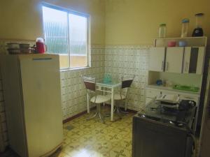 une cuisine avec une table, des chaises et un réfrigérateur dans l'établissement Apartamento Acolhedor, à Uberaba