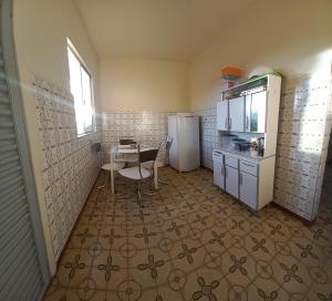 une cuisine avec une table et un réfrigérateur dans l'établissement Apartamento Acolhedor, à Uberaba 10 autres photos