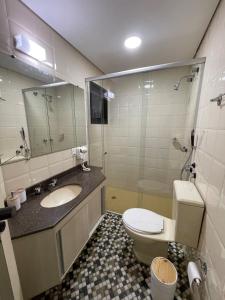 ein Badezimmer mit Toilette, Waschbecken und Spiegel in der Unterkunft Flat - Excelente localização e vista espetacular in São José dos Campos