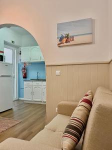 a living room with a couch and a kitchen at Nazaré Stay Home - Alecrim T2 in Nazaré
