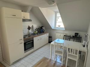 a kitchen with white appliances and a table and chairs at 64qm für 3 Personen in Niederdorla +29 photos
