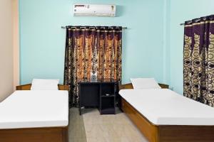 2 Betten in einem Zimmer mit Vorhang in der Unterkunft Hotel O Rainbow in Tezpur