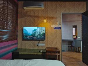 une chambre avec un lit et une télévision sur un mur dans l'établissement SECRET STUDIO On Factory, à George Town