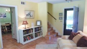 a living room with a couch and a book shelf at Ariel East Duplex in Jekyll Island