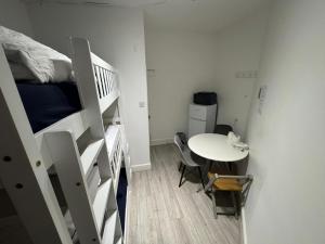 a small room with a bunk bed and a table at Trio Den in Zone 2 - Willesden Green in London