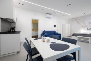 a kitchen and living room with a table and chairs at Meraviglia B&B - Salerno Centro Close to the Station and Pier in Salerno