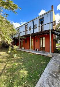 a red building with a balcony and a yard at El Granero Apart hotel in Mar del Plata