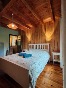 a large bed in a room with wooden walls at Louprayt in Saint-Julien-Chapteuil