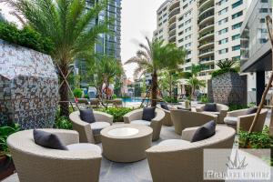 um pátio de resort com cadeiras e uma piscina em Lume Metro Saigon River em Cidade de Ho Chi Minh