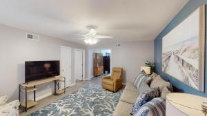 a living room with a couch and a tv at Turtle's Nest Duplex in Jekyll Island