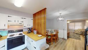 a kitchen with white cabinets and a table and a dining room at Turtle's Nest Duplex in Jekyll Island