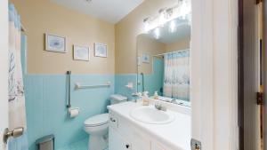 a bathroom with a sink and a toilet and a mirror at Turtle's Nest Duplex in Jekyll Island +7 photos