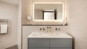 Un baño blanco con lavabo y espejo. en Hotel Indigo Torquay, By IHG, en Torquay