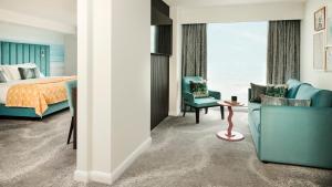 um quarto de hotel com uma cama e cadeiras e uma janela em Hotel Indigo Torquay, By IHG em Torquay