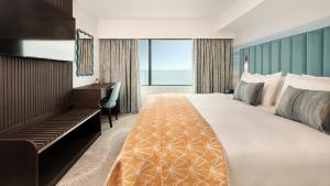 a hotel room with a bed and a desk and a window at Hotel Indigo Torquay, By IHG in Torquay +44 photos