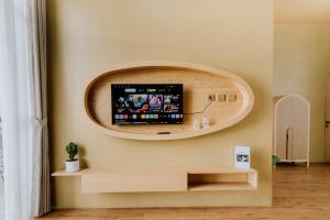 uma sala de estar com uma TV de tela plana na parede em cithara villa em Kejajar mais 17 fotografias