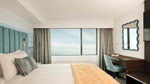 um quarto com uma cama, uma escrivaninha e uma janela em Hotel Indigo Torquay, By IHG em Torquay