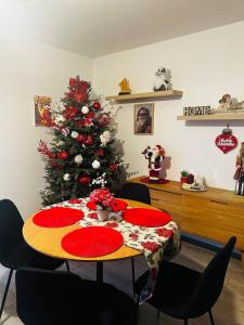 une table avec des plaques rouges et un arbre de Noël dans l'établissement Charming Apartment, à Strasbourg 1 autre photo