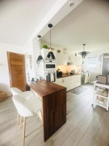 - une cuisine avec une table en bois et des chaises blanches dans l'établissement Charming Apartment, à Strasbourg