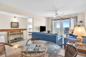 een woonkamer met een bank en een tafel bij Beechouse in Caswell Beach